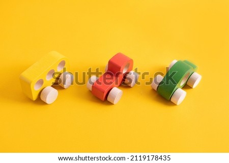 Wooden toy car in cartoon style on yellow background. Colorful and Transportation background, eco kid toys Montessori . 