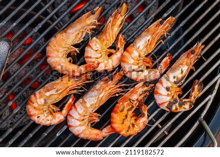 Grilled shrimp that's being cooked with smoke on the grill. Royalty-Free Stock Photo #2119182572