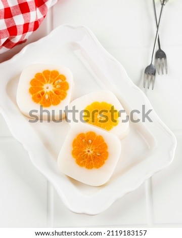 Milk Pudding with Fresh Orange at the Center, on White Table