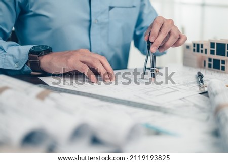 Architect engineer use compass drawing design working on blueprint. House planning design and construction concept.