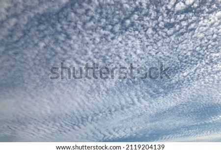 Altocumulus clouds with small streaks fill the beautiful sky. Often appears between lower stratus clouds and higher cirrus clouds photographed in Thailand.no focus Royalty-Free Stock Photo #2119204139