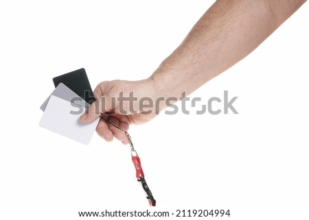 Hand holds a set of gray cards for adjusting white balance on a white background