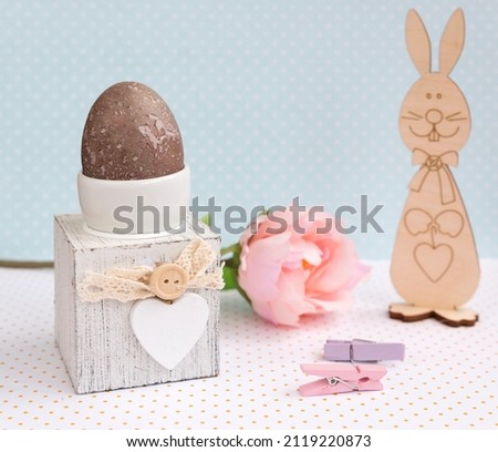 Easter composition on a delicate background, artificial peony decorations, Easter bunny, decorative clothespins. Close-up. Selective focus