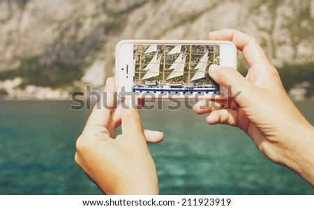 Sailing ship seen through lens of a mobile phone
