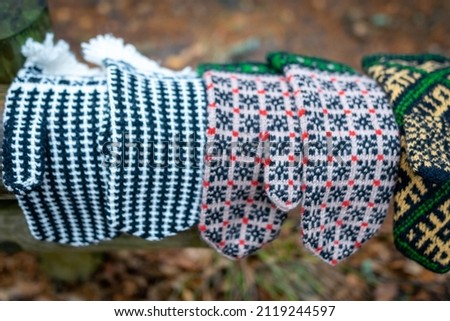 photography with knitted gloves on a natural earth background, handicraft concept, knitting as a hobby, a good way to spend free time is handicrafts