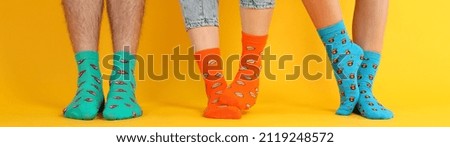 Legs in different socks on yellow background