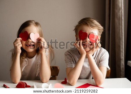 Kids painting red valetine heart card on table at home, lifestyle Royalty-Free Stock Photo #2119259282