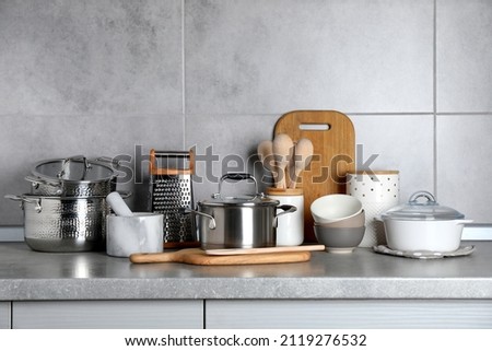 Set of different cooking utensils on grey countertop in kitchen Royalty-Free Stock Photo #2119276532