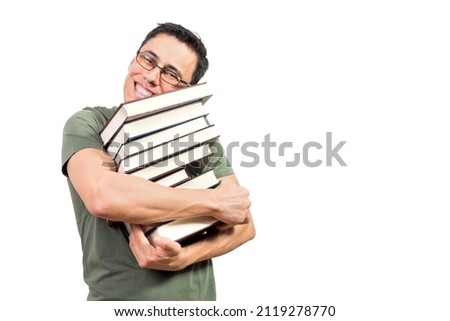 Optimistic nerdy man embracing stack of books