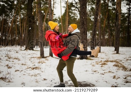 Happy young mixed race couple in park on winter day Royalty-Free Stock Photo #2119279289