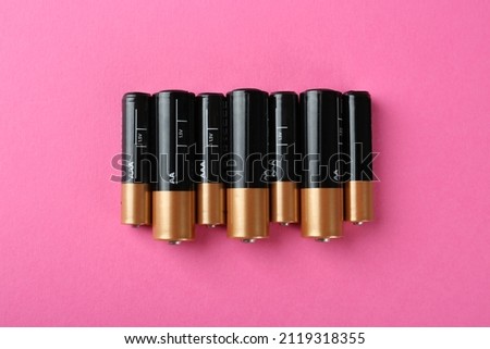 Many different batteries on pink background, flat lay Royalty-Free Stock Photo #2119318355
