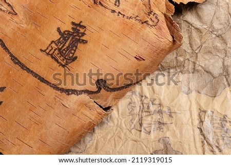 Scraps of old nautical charts on paper and birch bark depicting sailing ships.