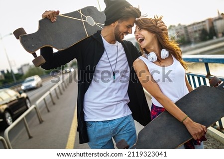 Portrait of young happy people with skateboards having fun together outdoors
