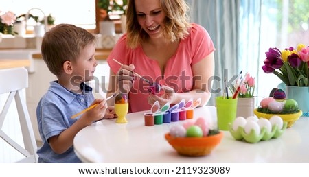 Mother and son are painting eggs at home Royalty-Free Stock Photo #2119323089