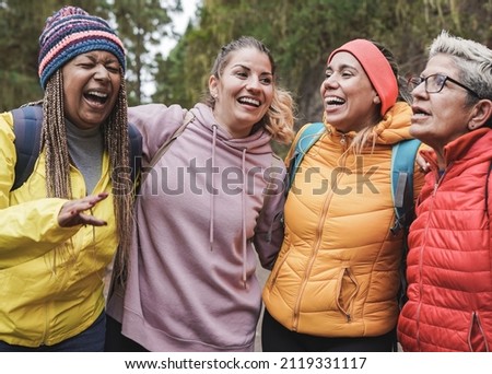 Happy multiracial women hugging together during trekking day - Multi generational female friends enjoy day outdoor in nature Royalty-Free Stock Photo #2119331117