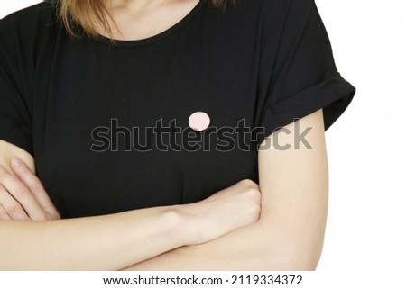 Small button badge pinned onto black shirt	 Royalty-Free Stock Photo #2119334372