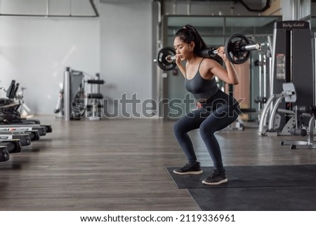 Asian woman exercise in fitness. Young healthy woman in sportswear doing legs exercise in fitness. Royalty-Free Stock Photo #2119336961