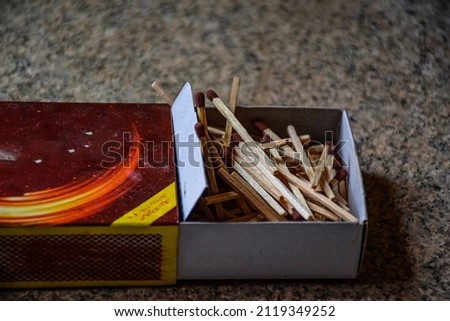 Stock photo of half open match box with large numbers of match sticks kept on floor on blur background. Picture captured under natural light at Bangalore , Karnataka, India.