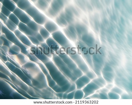 Reflection​ on​ surface​ blue​ water​ in​ the​ sea. Abstract​ of​ surface​ blue​ water​ for​ background. Closeup​ abstract​ of​ surface​ blue​ water. Splash​ed​ water​ in the​ ocean​. Water​ texture.