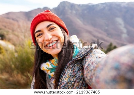 Young beautiful hiker woman taking selfie portrait on the top of mountain - Happy smiling girl using her smartphone - Hiking and climbing cliff