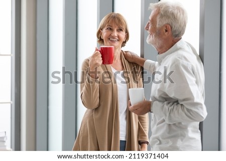 senior businesswoman holding a cup of coffee and talking about work in free time