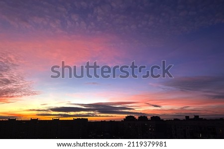 Cloudy rose blue sunset over dark silhouettes of city buildings, top view. Evening view. High quality photo Royalty-Free Stock Photo #2119379981
