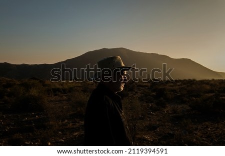 Adult man in cowboy hat on Tabernas desert during sunset. Almeria, Spain