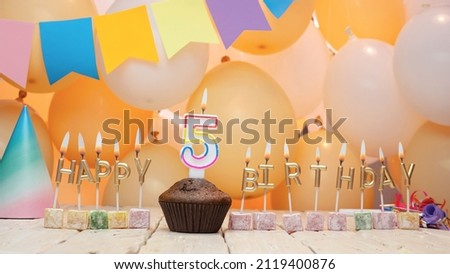 Happy birthday greetings for a child of 5 years old from golden letters of candles burning against the background of mine space balloons. Beautiful birthday card number 5. Five years