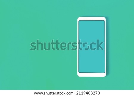 The concept of online trading. A white phone with a blue flat screen on a blue background.