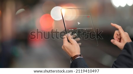 Live video marketing concept. Businessman hand holding transparent screen and tuching on start button to run video clip.