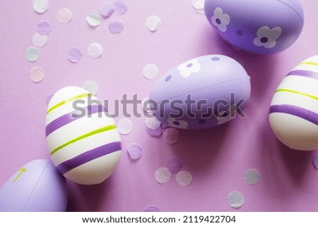 painted easter purple eggs with ornament and decor on pastel background. copy space.