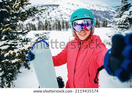 Woman sportsman snowboarder make selfie photo on action camera. Travel Sunset Sheregesh, Kemerovo region Russia.