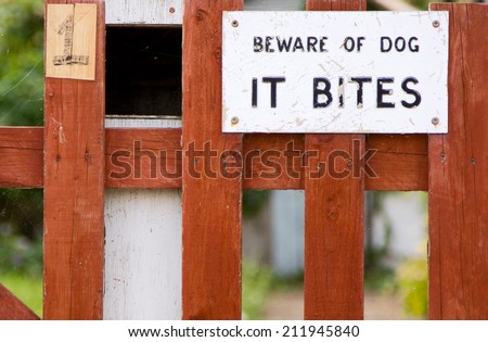 dog bites sign on a garden gate.