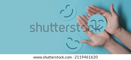 Hand holding blue paper cut happy smile face, positive thinking, mental health assessment , world mental health day concept	 Royalty-Free Stock Photo #2119461620