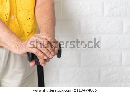 Asian elderly woman holding a walking stick on isolate background. The concept aging society That needs time and grandchildren to come back to caring for healthcare