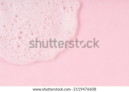 White cleanser foam drop on pink background. Soap, shower gel, shampoo foam texture closeup Royalty-Free Stock Photo #2119476608