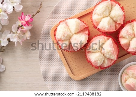 Top view of cute tasty fresh traditional Chinese steamed sponge cake - Fa Gao on wooden table background for spring festival celebration food in pink and white color. Royalty-Free Stock Photo #2119488182