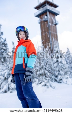 Happy preteen children on ski slope, enjoying snow wintertime