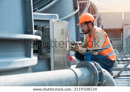 Engineer under checking the industry cooling tower air conditioner is water cooling tower air chiller HVAC of large industrial building to control air system. Royalty-Free Stock Photo #2119508534