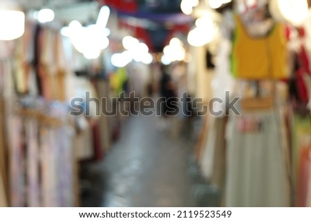Defocused outdoor flea market at night with nobody and lights in background. Picture was blurred in purpose.