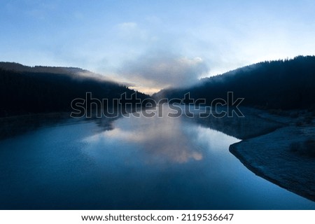 Aerial view of a misty lake. Dawn dark lights during sunrise, cold weather