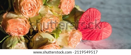 delicate bouquet of bushy peony roses and red heart on marble background.Happy Valentines day.Flowers for birthday, valentines ,mothers, womans day. web banner