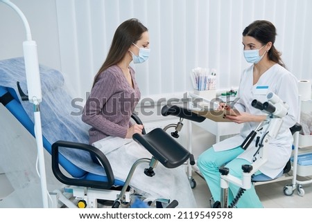 Concentrated gynecologist listening to her patient complaints Royalty-Free Stock Photo #2119549598