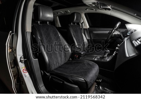 fabric seat cover in a car in a black interior Royalty-Free Stock Photo #2119568342