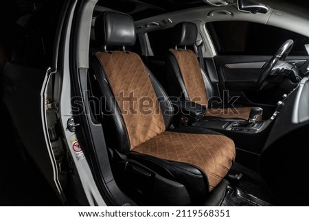 fabric seat cover in a car in a black interior Royalty-Free Stock Photo #2119568351