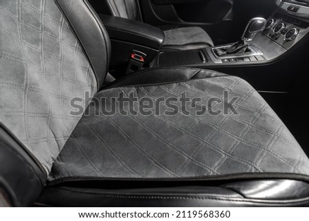 fabric seat cover in a car in a black interior Royalty-Free Stock Photo #2119568360