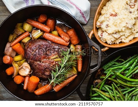 Pot roast in a cast iron dutch oven, green beans and mushed potato. Royalty-Free Stock Photo #2119570757