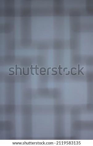 Abstract blurry bokeh of a moving rectangular grid with grey and blue.