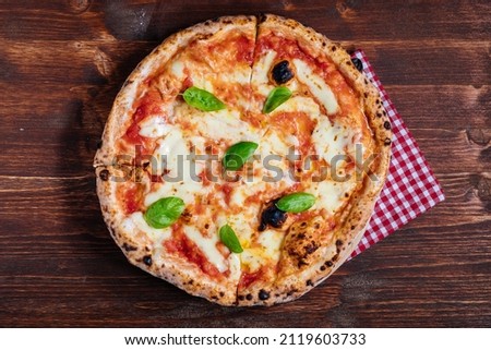 Pizza Napoletana, traditional and authentic Italian pizza baked in wood fired oven. Margherita pizza with mozzarella cheese, tomato sauce, olive oil and basil leaves. International pizza day