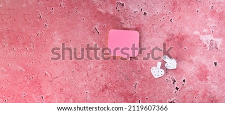 Pink stickers lie on a pink background. Clothespins white with a heart on a pink background with copy space